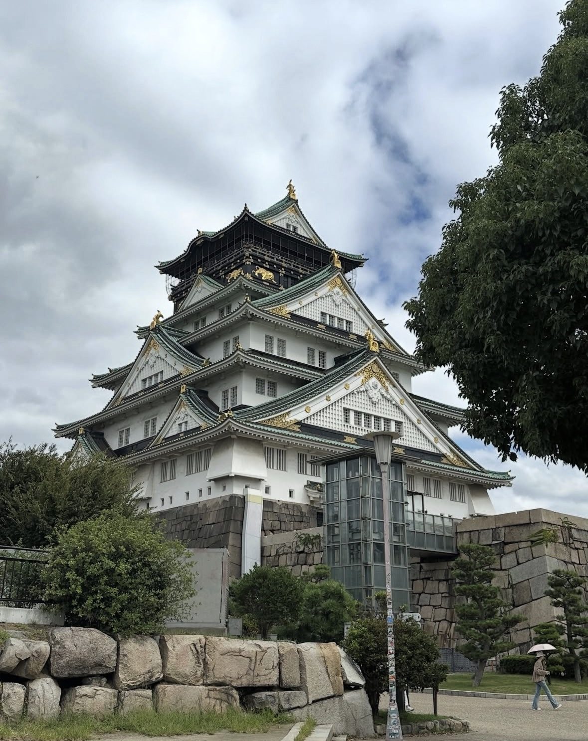 Osaka Castle tower surrounded by vibrant cherry blossoms in spring with blue sky in the background